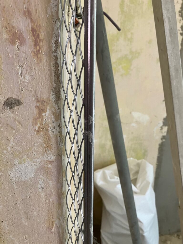 Rekonštrukcia bytu v Rači počas prác: rohová lišta na hrane steny pred omietkou