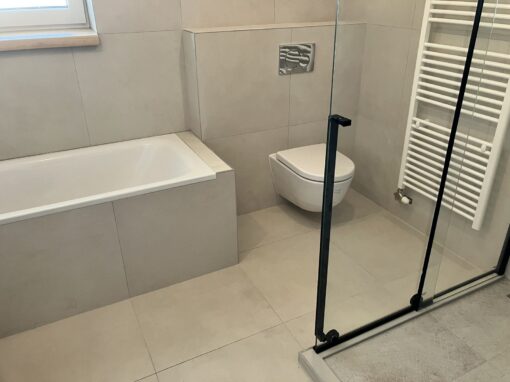 Zrekonštruovaná kúpeľňa s vaňou, závesným WC a sprchovou zástenou s čiernym rámom Prerábka kúpeľne: zrekonštruovaná kúpeľňa s vaňou, závesným WC a sprchovou zástenou s čiernym rámom