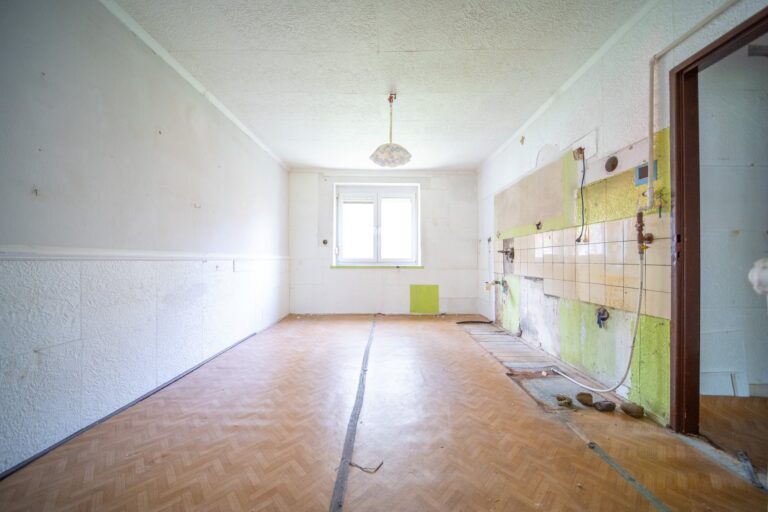 Rekonštrukcia bytu v Rači pred začiatkom prác: kuchyňa bez linky so zvyškami starého obkladu